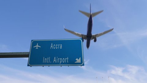 accra airport sign airplane passing overhead