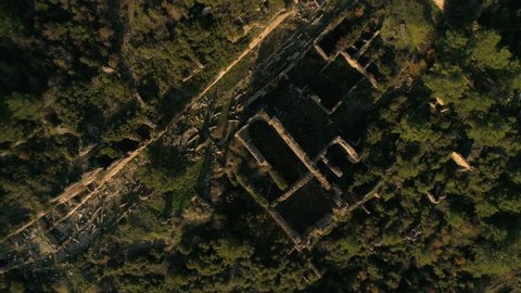 Above view from drone circling and moving up at the old ruined Syedra Castle on the rocky Taurus Mountains covered with forests. Antalya Province in Turkey. 4k, slow motion.