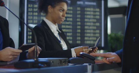 Crop view of people passing through registration counter with multiracial receptionists in airport having biometric control. 4K shot on Red cinema camera.