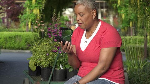 Senior woman talking on phone in a garden