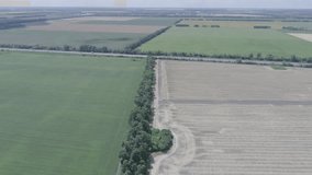 Aerial view of various fields separated by road and motorway in the background. Ukraine. 4k video
