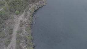 Aerial view of a beautiful lake at the site of a former granite quarry near the town of Korostyshev, Ukraine. 4k video. Beautiful landscapes of wild nature with a lake with high banks of stone