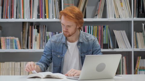 Redhead Man Reading Book, Sitting in Library
