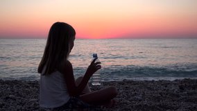 Child Drinking Water on Beach at Sunset, Girl Watching Sea Waves on Seaside 4K