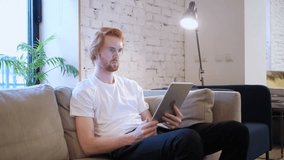 Online Video Chat on Tablet by Redhead Man in Office