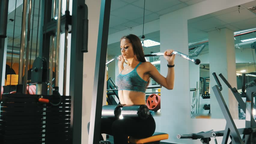 Gym woman strength training lifting dumbbell weights getting ready for exercise workout. Female fitness girl exercising indoor in fitness center Royalty-Free Stock Footage #1008604198