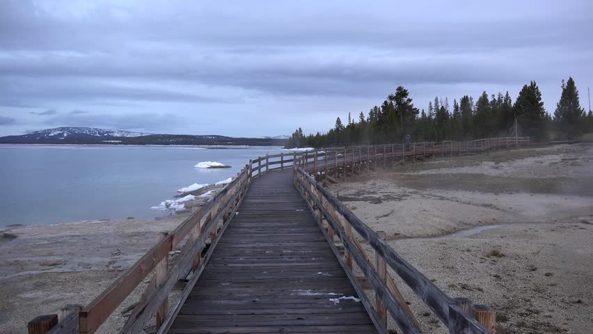 Boardwalk along the lake Yellowstone in West Thumb Geyser Basin at spring. Wyoming, USA