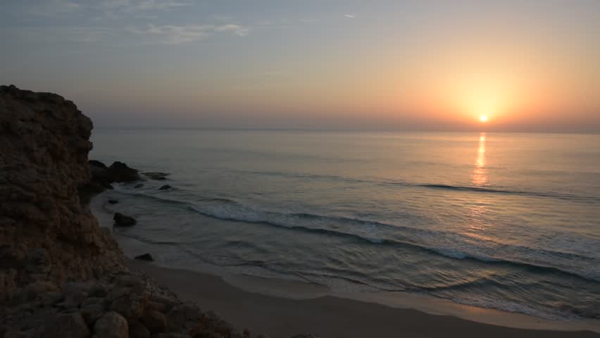 Sun rising above the ocean Indian sea at the wild coast of Ras Al Jinz, a famous touristic destination to observe turtles nesting on beaches. Sultanate of Oman