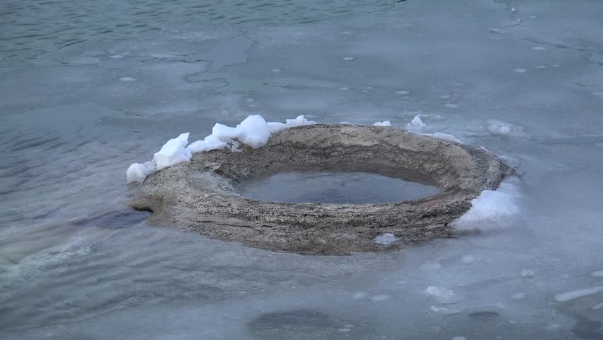 Fishing Cone Hot Spring surrounded by ice in West Thumb Geyser Basin. Yellowstone NP, Wyoming, USA.