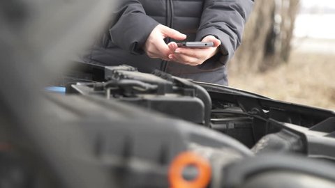 Woman uses the phone after the car has broken down
