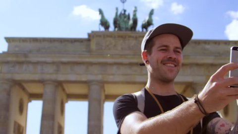 guy takes a selfie with the Brandenburg gate in the back