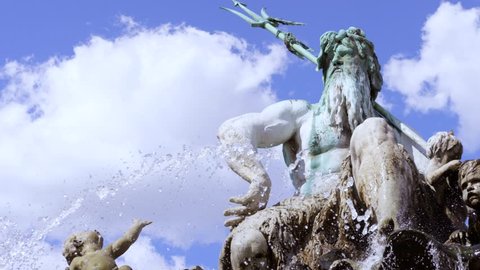 fountain with statue of Poseidon in Berlin in slowmotion and a church in the back