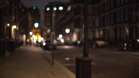 Left to right pan of empty residential street in London in evening. Defocused shot of empty urban street, people tucked in for the night at home. 4k