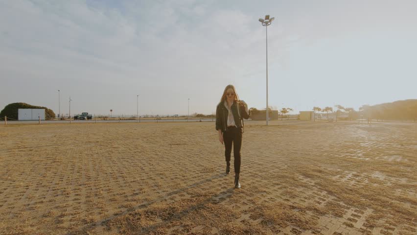 Independent and empowered confident attractive and beautiful young woman puts her handbag on passenger seat and walks around to sit in small red convertible cabriolet car, proud owner, chic lifestyle