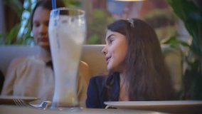 the girls teen communicate in a cafe are friends. children teens sitting in cafe fast food slow motion video