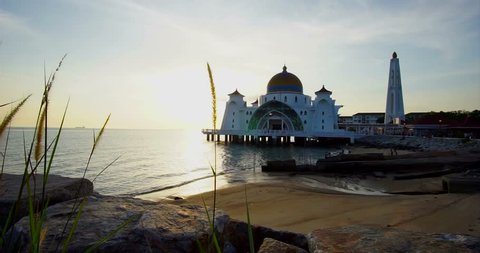 4K realtime footage of the Straits Mosque Melaka Malaysia with foreground of waving long grass.