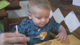 baby boy eats bread in a restaurant