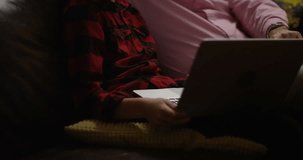 4K Young boy & his grandfather watching a movie on laptop late at night. Slow motion.