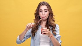 Young beautiful caucasian woman giving up and eating chocolate over yellow background