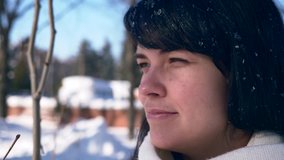 Close-up Pretty Female Face. Snowflakes On Hair. Young Adult In Snow Covered City Park On Sunny Day. City Life. Slow Motion 30 fps 1/2 real time speed 60 fps