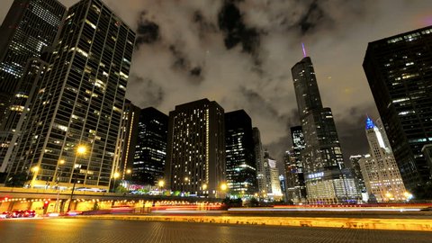 Chicago Skyscrapers at Night with Traffic Crossing the City. Video timelapse of Chicago downtown skyscrapers with cars driving at full speed on its streets. Awesome Chicago city center black skyline.