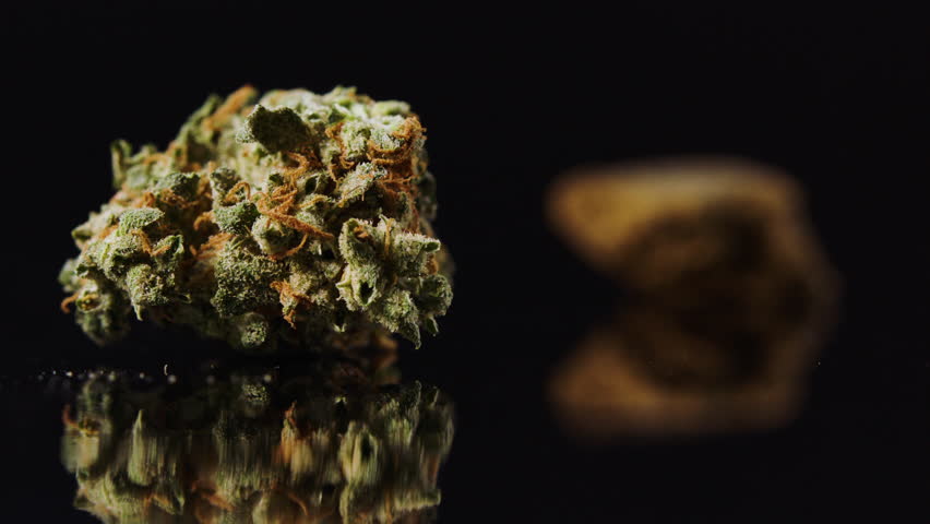 Cannabis bud on black rack focus to chunk of hash
