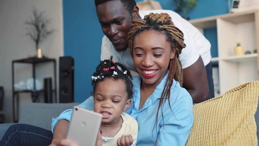 Happy young family taking selfie, brightly smiling straight to phone’s camera. Family portrait, childhood memories. Close up view, camera stabilizer shot | Shutterstock HD Video #1008693133