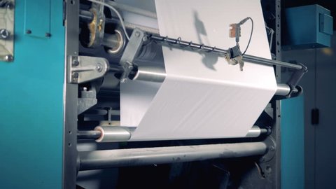 Industrial paper roll is being processed by an industrial machine. 4K.