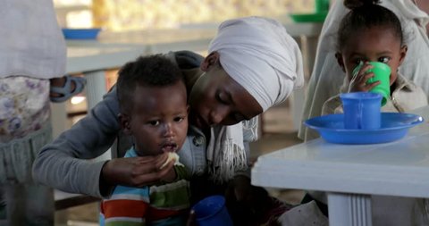 GONDAR, ETHIOPIA - JANUARY 18, 2017: Ethiopia Gondar african poor mother feed her sun poverty village people