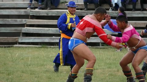 Telmen sum, Mongolia - July 15, 2017: Mongolian national holiday Naadam. Competition wrestlers in the open stadium. Batyrs try to knock each other down. Editorial use.