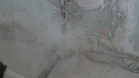 drilling of concrete with a round construction crown. worker drills a wall with a perforator. Slow motion video