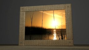 Concept animation of a photograph of an amazing sunset over a lake coming to life. Water cascades from the frame and the photo becomes a moving clip.