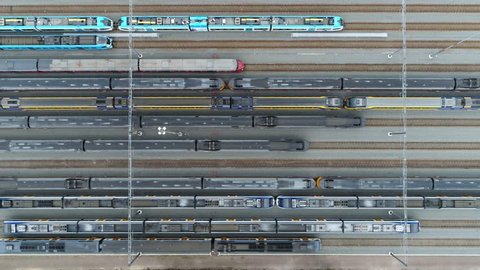 Aerial top down footage of railway transportation hub showing the different trains parked next to each other on the rails very smooth and right movement keeping the horizontal lines straight 4k