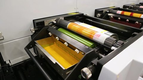Flexography printing process on in-line press machine. Video of photopolymer plate stuck on printing cylinder, substrate is sandwiched between the plate and the impression cylinder to transfer the ink