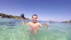 Beautiful girl prepares snorkeling mask for diving, SLOW MOTION stock video