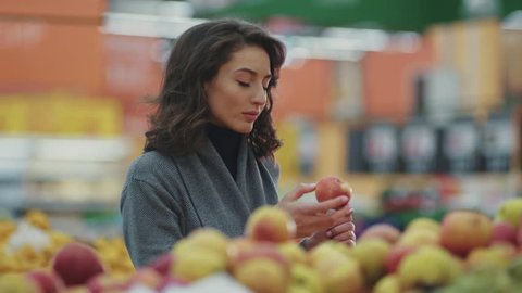 Close up young woman choosing apple at fruit vegetable supermarket marketplace