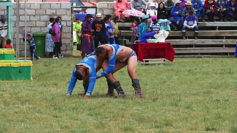 Telmen-sum, Mongolia - July 15, 2017: Mongolian national holiday Naadam. Fighters compete against each other in an open stadium. Capture and throw. One wrestler throws another on the ground.  