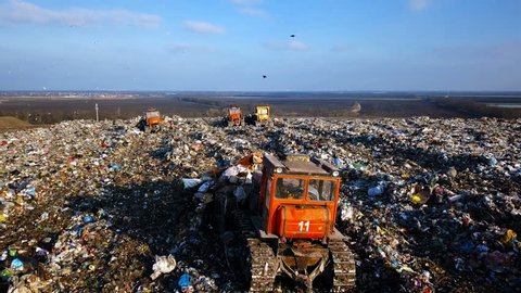 City Dump. The Bulldozer Compacts the Garbage on the Landfill. Wastes of Human Life. Aerial View
