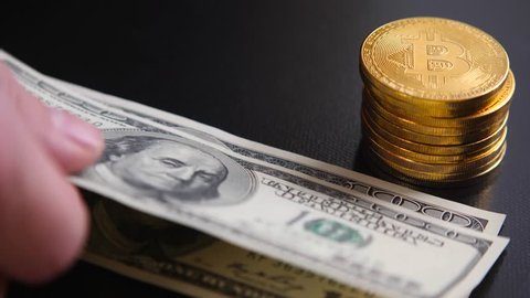 Golden bitcoins on hundred-dollar bills. Virtual money replacement paper
