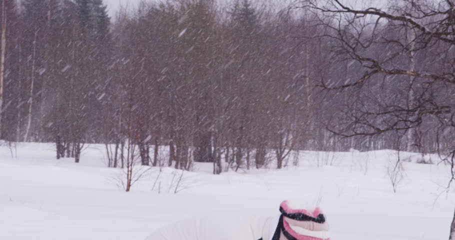 The girl is throwing snow up.