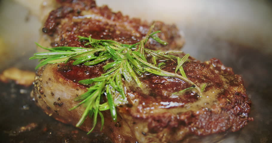 Beef steak with rosemary frying on a pan in a professional restaurant kitchen Royalty-Free Stock Footage #1008747446