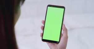 woman take cell phone with green screen