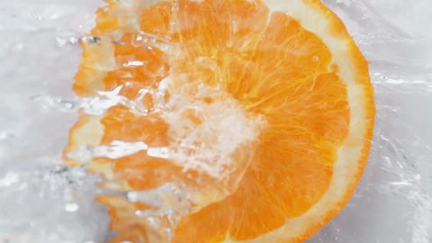 Water splash on halved orange. Shot with high speed camera, phantom flex 4K. Slow Motion.