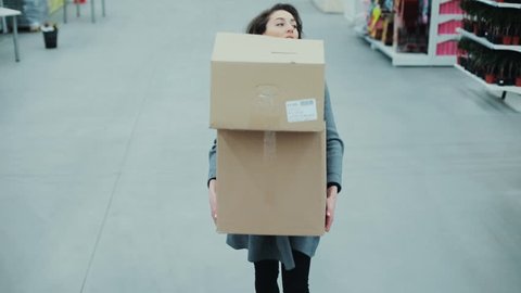 Attractive woman carries heavy boxes heavily inhaled hurry in a supermarket thinking shopping internet buy technology hypermarket shop mall smartphone grocery market girl food customer slow motion