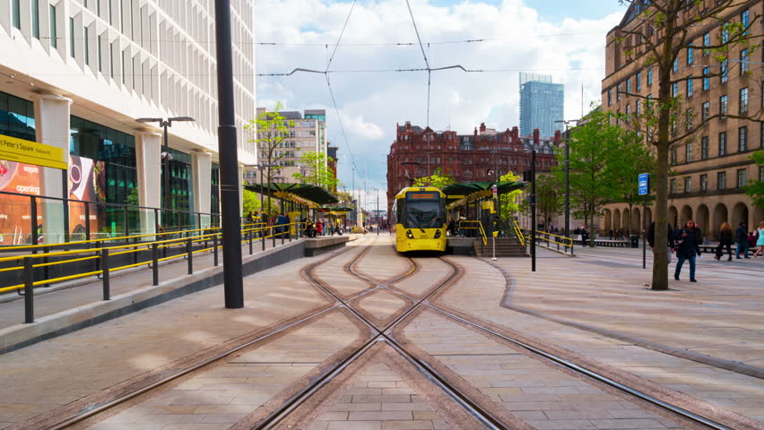 MANCHESTER, ENGLAND - MAY 20, 2017: Light rail yellow tram Metrolink in city center of Manchester, UK in the evening. The system has 77 stops along 78.1 km and runs through seven of the ten boroughs.  Royalty-Free Stock Footage #1008764585