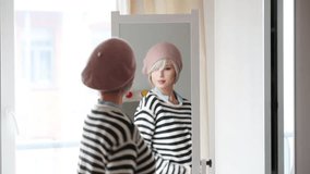 Young blonde girl dressing up at home near a mirror.