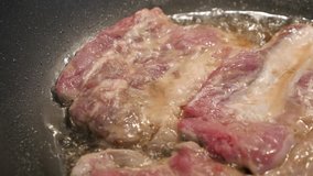 Preparing meat in hot oil close-up 4K 2160p 30fps UltraHD footage - Pork steaks in frying pan 3840X2160 UHD video