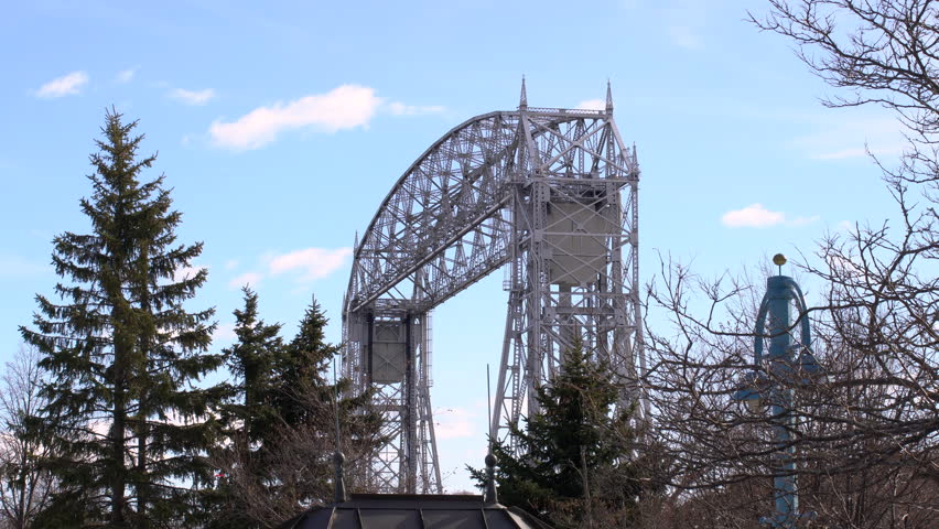 Long shot of the Aerial Lift Bridge in Duluth, Minnesota as it is suspended in air waiting for a boat to pass beneath