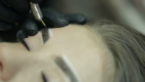 Close up of cosmetologist making microblading procedure.