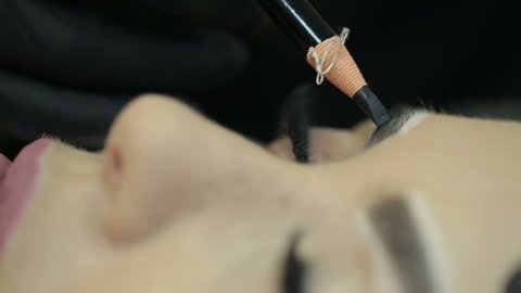 Close up of cosmetologist making microblading procedure.